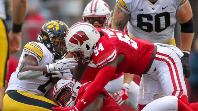 Wisconsin linebackers Maema Njongmeta (55) and Jordan Turner (54) tackle Iowa running back Kaleb Johnson (2) on Saturday, October 14, 2023, at Camp Randall Stadium in Madison, Wis. Iowa won the game, 12-6.